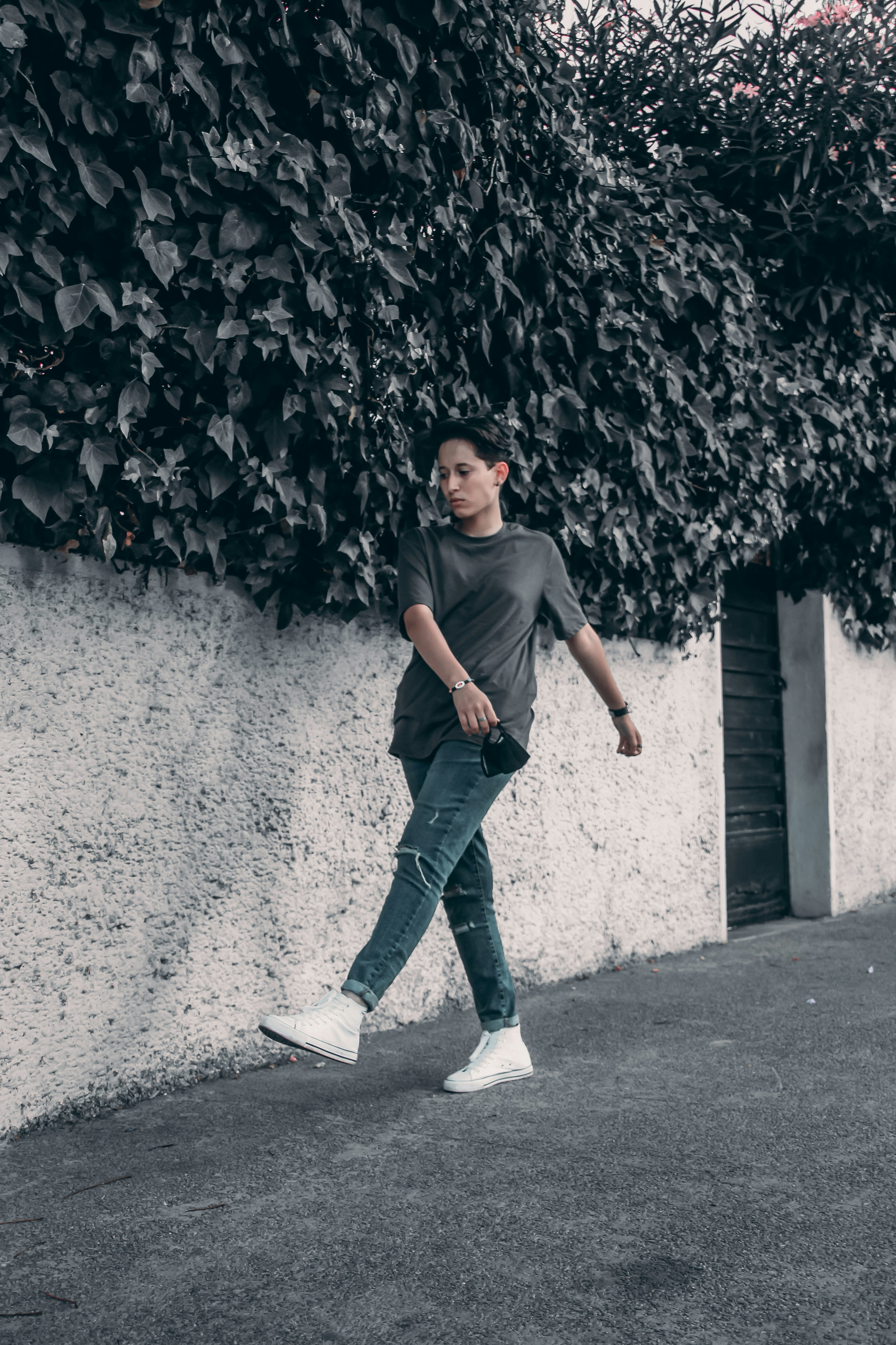 man in gray crew neck t-shirt and blue denim jeans standing on gray concrete floor